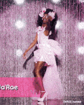 a woman in a pink dress and heels is dancing on a stage