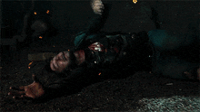 a man in a leather jacket is laying on the ground