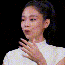 a close up of a woman 's face with a ponytail and a white shirt .