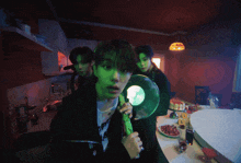 a group of young men are standing around a table with food