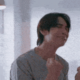 a man is making a funny face with his fist in the air while sitting at a table .