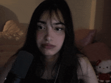 a girl talking into a microphone in front of a hello kitty