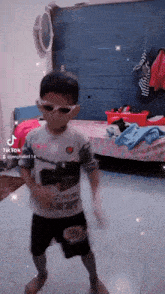 a young boy wearing sunglasses and a shirt that says ' tik tok '