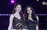 a couple of women standing next to each other in front of a purple background with a circle that says 3hc