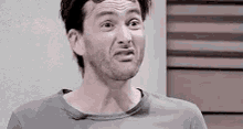 a man with a beard is making a funny face with his mouth open .