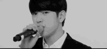 a man singing into a microphone in a black and white photo