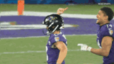 a football player wearing a ravens helmet is pointing up