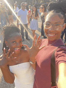 two women posing for a picture with one wearing a necklace that says ' i love you '