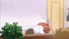 a person is laying on a couch in a room with a plant in the foreground .