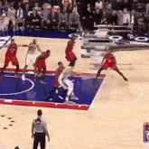 a basketball game is being played on a court with a referee wearing a number 44 on his back
