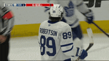 a hockey player wearing a number 89 jersey stands on the ice