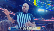 a referee stands in front of a scoreboard that says arizona 3-0 ucla 3-0