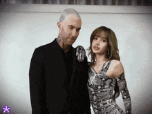 a man in a suit and a woman in a dress pose for a picture
