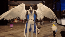 a man with angel wings is standing in front of a crowd of people
