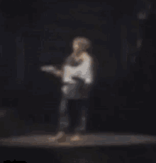 a blurry picture of a person standing on a stage in a dark room