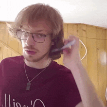 a man wearing glasses and a red shirt that says ' illio ' on it