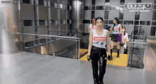 a group of women are walking down a staircase in a building .