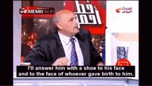 a man in a suit and tie is talking on a tv show called the memri