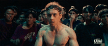 a man in a shirt that says envs stands in a crowd