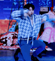 a man in a blue sweater is dancing on a stage