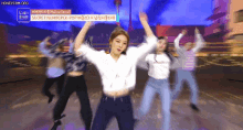 a group of women are dancing in front of a banner that says secret number