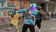 a group of people are dancing in front of a wall that says t grey school
