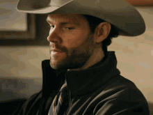 a man wearing a cowboy hat and tie