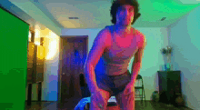 a man is standing in a room with a green screen in the background