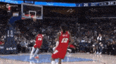 a basketball game is being played in front of a crowd .