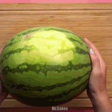 a person is holding a watermelon on a wooden cutting board and the words mr.cakes are on the bottom