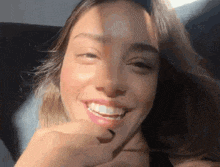 a close up of a woman 's face with her hand on her face