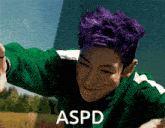 a man with purple hair is wearing a green jacket and the word aspd is on the bottom