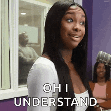 a woman in a white top is standing in front of a microphone and says oh i understand .