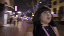 a blurry picture of a woman walking down a street with a sign that says i on it