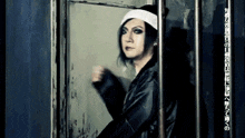 a man in a prison cell with a bandana on his head behind bars