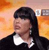 a woman is wearing chanel earrings and a black shirt