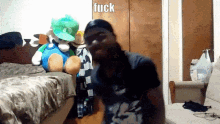a man is standing in front of a stuffed animal with the word fuck written on it