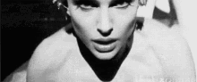 a black and white photo of a woman 's face with a shadow on her face .