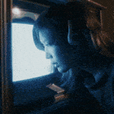 a woman wearing headphones is looking at a screen
