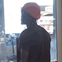 a man wearing a red hat is standing in front of a window with the word efc on it