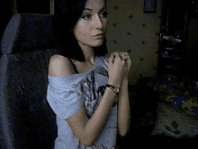a woman wearing a watch is sitting in a chair with her hands folded in front of her face