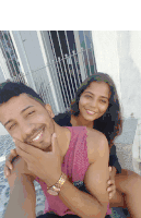 a man and a woman are posing for a picture and the man is wearing a pink tank top