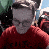 a person wearing glasses and a red shirt that says ' realtree ' on it