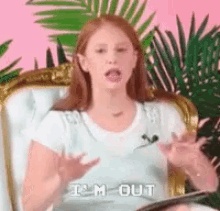 a woman is sitting in a chair talking into a microphone and says `` i 'm out '' .