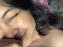 a close up of a woman 's face with a flower on the floor