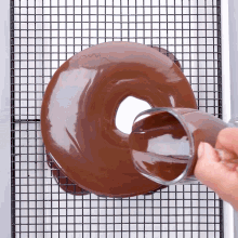 a chocolate donut is being poured with a glass