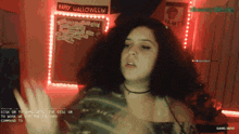 a woman in front of a sign that says " happy halloween "
