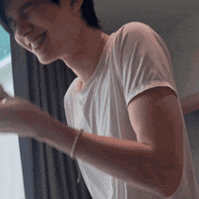 a man in a white shirt is smiling with his eyes closed and his arms outstretched