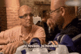 two men are sitting at a table and one of them is saying " jsi hovado "