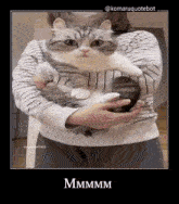 a woman is holding a cat in her arms and the caption says mmmm